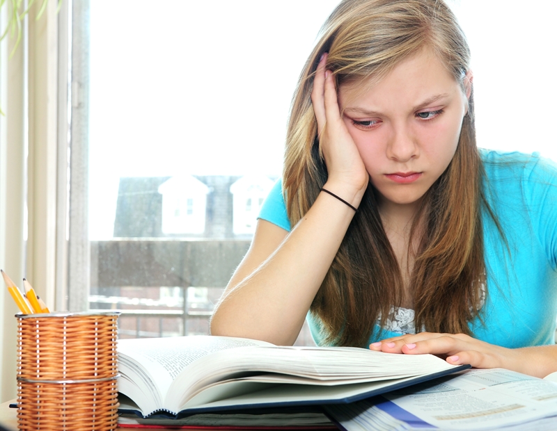 Teenage girl studying with textbooks_small